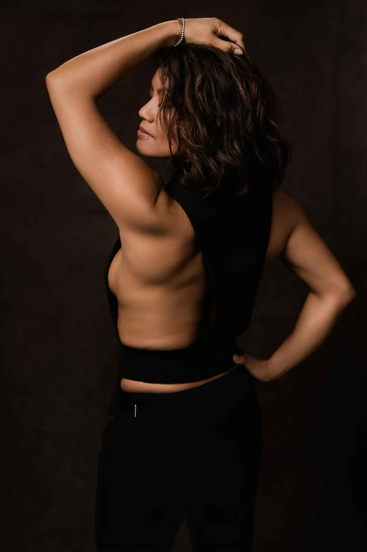 Boss Babe Lijnie in a backless black top, hand in hair